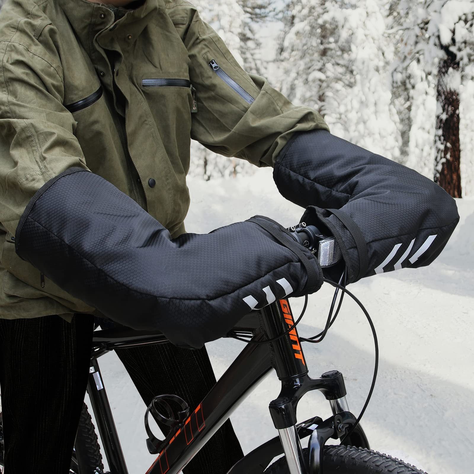 Person wearing black bike handlebar covers with white stripes on a snowy background